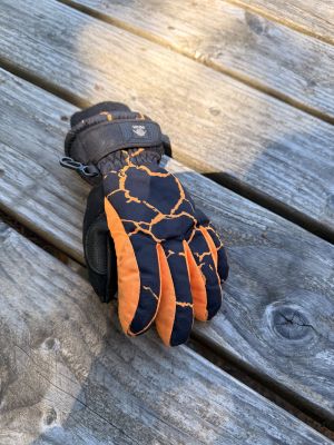 Singular black and orange snow glove